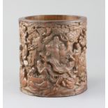 A Chinese bamboo 'eighteen luohan' brush pot, late Qing dynasty, the exterior carved in high