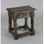 An oak joined stool, with foliate carved frieze, fluted legs and all round stretchers, W.1ft 8in.