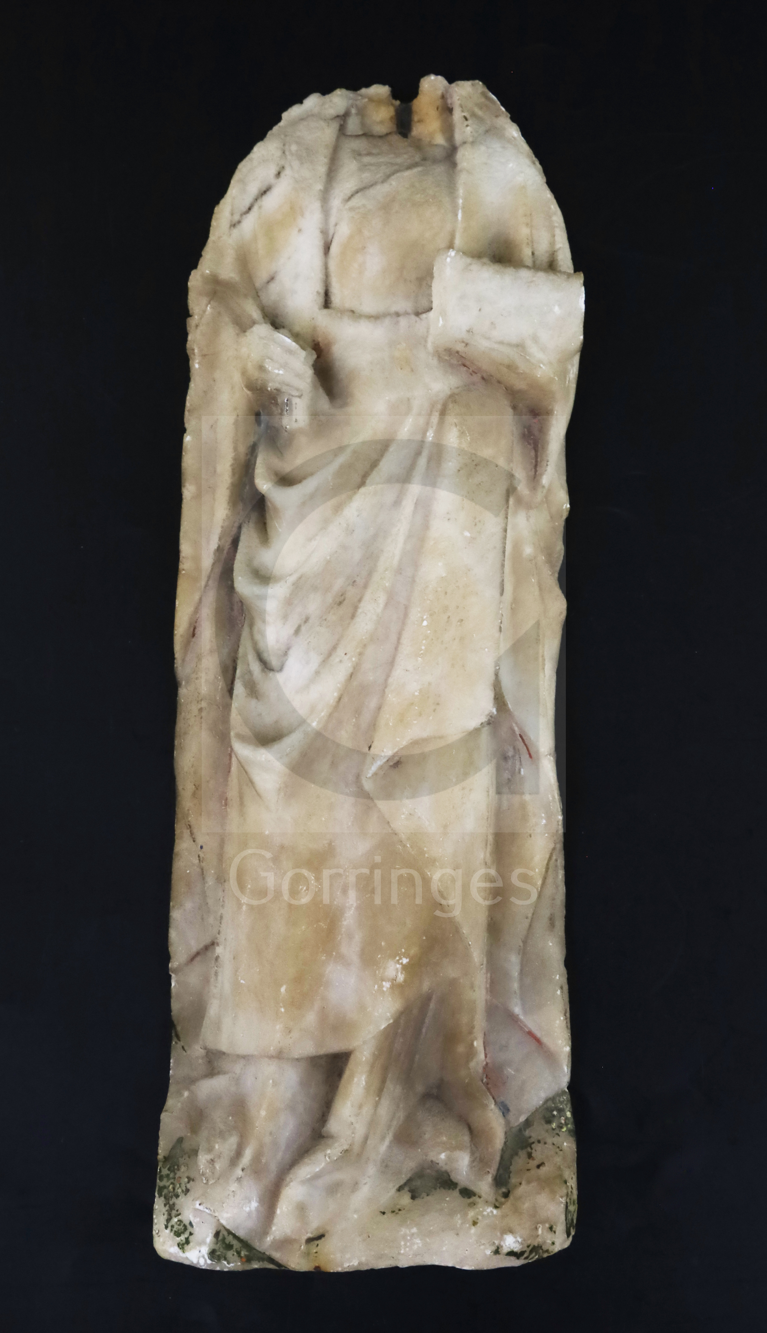 A Nottingham alabaster plaque, carved with the body of a medieval lady holding a book, traces of