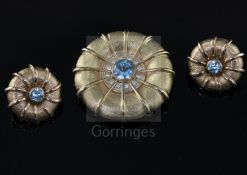 A late 1990's 9ct gold, blue zircon and diamond set circular pendant brooch, and a similar pair of