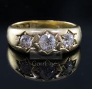 A late Victorian 18ct gold and gypsy set three stone diamond ring, the central stone weighing