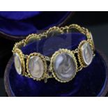A cased Victorian gold and glazed plaited hair oval panel family memento bracelet, comprising nine