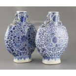 A pair of Chinese blue and white moonflasks, 19th century, each painted with lotus flowers and