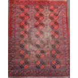 An Afghan aubergine and red ground carpet, with field of octagons and geometric motifs, 11ft 6in
