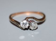 A yellow metal and two stone diamond crossover ring, size J/K.