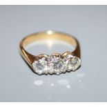 A modern 18ct gold and three stone diamond ring, the central stone weighing approximately 0.40cts,