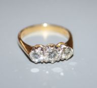 A modern 18ct gold and three stone diamond ring, the central stone weighing approximately 0.40cts,