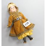 An Armand Marseille doll dressed in Russian dress H.23cm