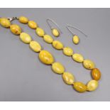 A single strand graduated amber bead necklace and pair of similar earrings, gross weight 36 grams,