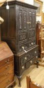 An 18th century large oak cupboard, fitted doors over one long and five short drawers, all later