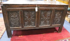 A late 17th century carved and panelled oak coffer, with planked top W.124cm