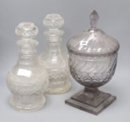 A pair of cut glass decanters and a cut glass lidded pedestal jar height of tallest 40cm