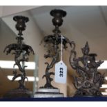 A pair of decorative metal candlesticks and a Thai deity