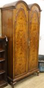 A 1930's figured walnut double dome two door wardrobe W.100cm