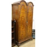 A 1930's figured walnut double dome two door wardrobe W.100cm