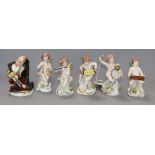 A Crown Naples figure of a hump back musician and five Capodimonte figures of cherubs