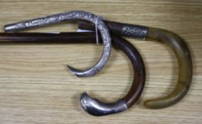 An Indian white metal cane handle, one other and a white metal mounted walking cane.
