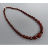 A single strand simulated cherry amber oval bead necklace, gross weight 56 grams, 55 cm.