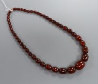 A single strand simulated cherry amber oval bead necklace, gross weight 56 grams, 55 cm.