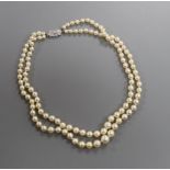 A double strand graduated cultured pearl necklace, with diamond set white metal clasp, 38cm.