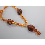 An amber necklace, with facetted beads and three carved Buddha, gross weight, 38 grams, 78cm.