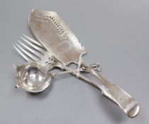 A George IV silver fish slice a later matching serving fork and a silver tea strainer.