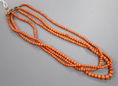 An early-mid 20th century triple strand graduated coral bead necklace, with yellow metal and coral