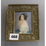 An ivory-painted miniature of a lady in pierced brass frame