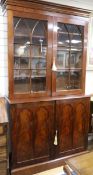 A Victorian mahogany library bookcase, the base fitted with an arrangement of twenty two drawers