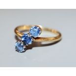 A three-stone light blue sapphire ring, 18ct yellow gold setting, size L.