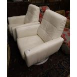 A pair of contemporary white leather swivel armchairs