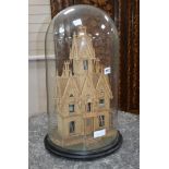 A 19th century carved cork house under glass dome