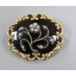 A 19th century pinchbeck , black enamel and seed pearl set mourning brooch, 45mm.
