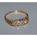 A modern Victorian style 18ct gold and graduated four stone diamond half hoop ring, size T.