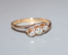 An '18ct and plat', three stone diamond crossover ring, size P.