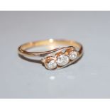 An '18ct and plat', three stone diamond crossover ring, size P.