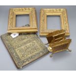 An Arts & Crafts brass blotter case, a pair of gilt frames and a letter rack