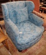 An early 20th century upholstered wingback armchair