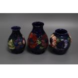 Three small Moorcroft Anemone pattern blue ground vases, each with impressed/painted marks, H