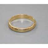 An unmarked yellow metal wedding band, size Y.