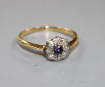 An 18ct and plat, sapphire and diamond cluster set flower head ring, size O.
