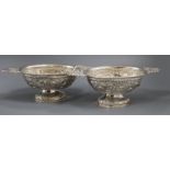 A matched pair of early 20th century Dutch repousse silver oval two handled pedestal sweetmeat