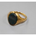An early 20th century yellow metal and bloodstone set oval signet ring, size P.