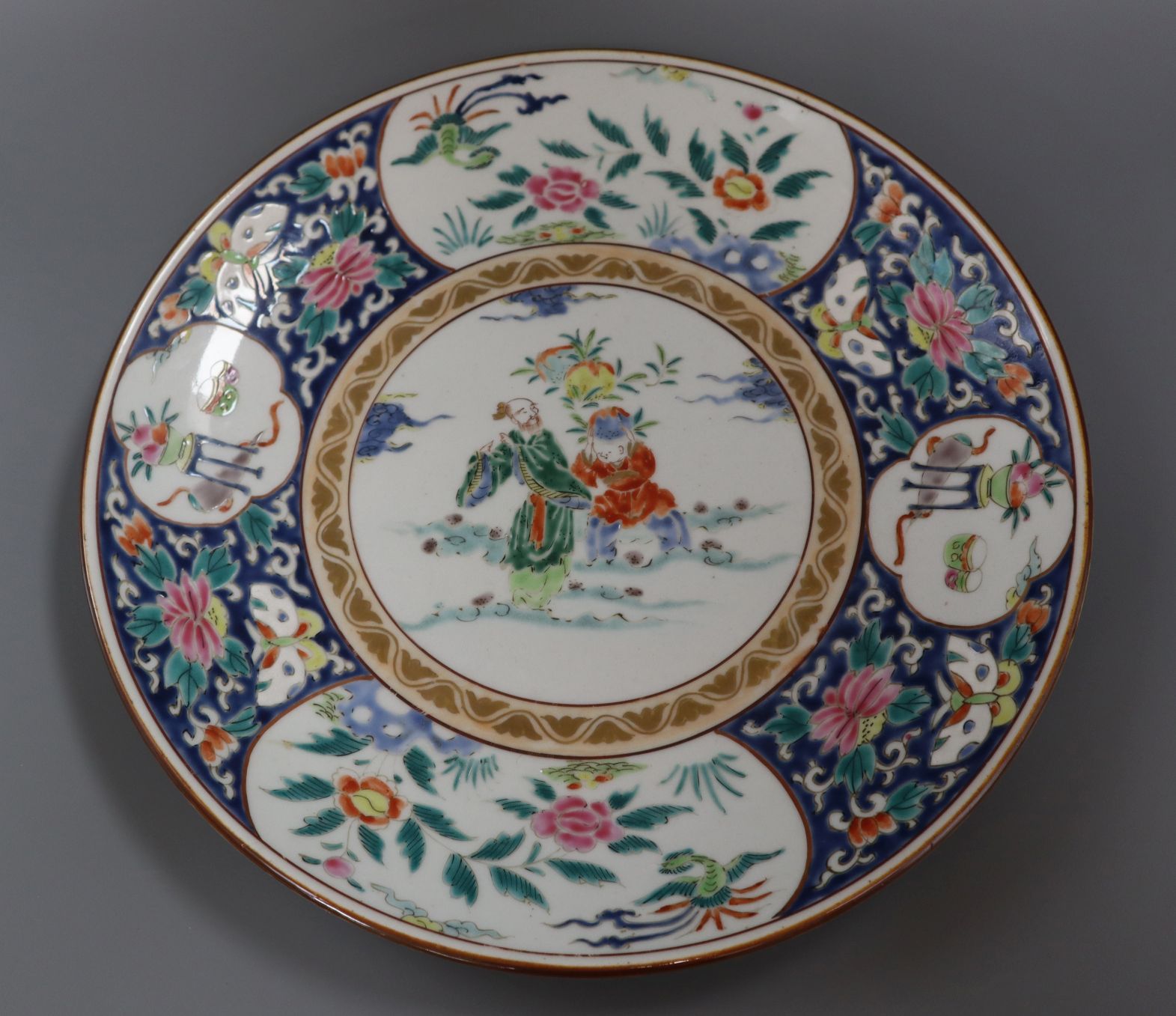 A Japanese polychrome-decorated charger, painted with figures, flowers and insects in reserves,