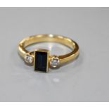 A modern 18ct gold, sapphire and diamond three stone ring, size M.