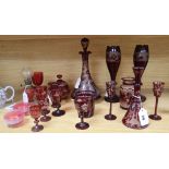 A collection of cranberry and engraved ruby glassware, including a decanter and stopper, a small