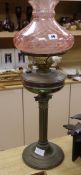 A brass oil lamp with cranberry shade height 72cm