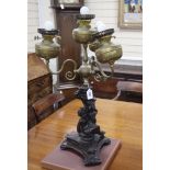 An ornate putti spelter three branch four light table lamp height 76cm