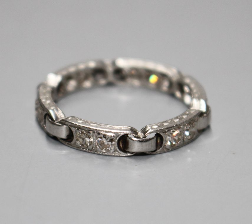 An unusual white metal (stamped Plat) and twelve stone diamond set eternity ring, with six 'chain'