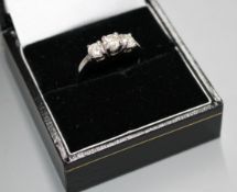 A modern 14k white metal and three stone diamond ring, with a total approximate carat weight of 0.